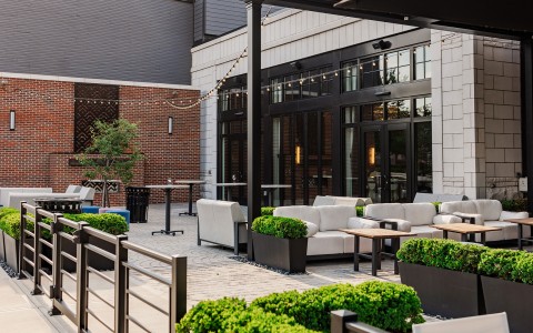 a patio area with white furniture and plants