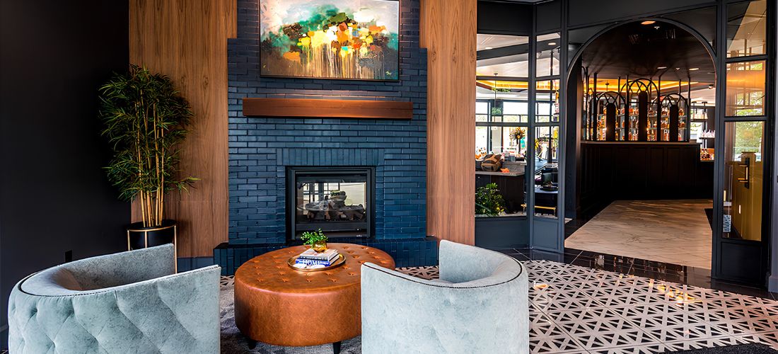 a room with a fireplace and a round ottoman