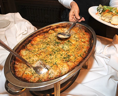 a person holding a spoon in a bowl of food