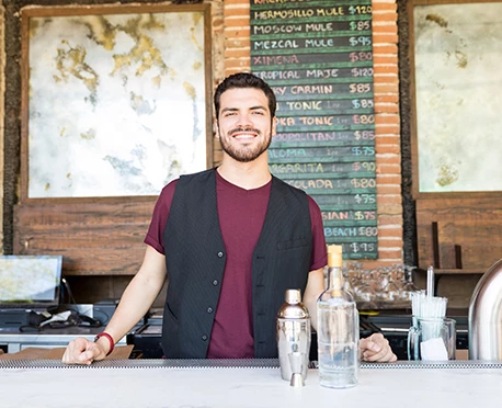 a man standing behind a bar counter