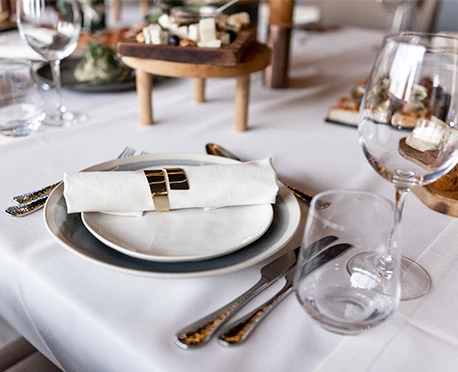 a plate with napkin on it and a glass of wine on a table