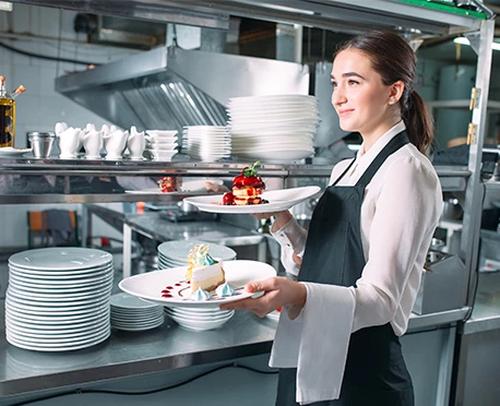 a woman holding plates of desserts