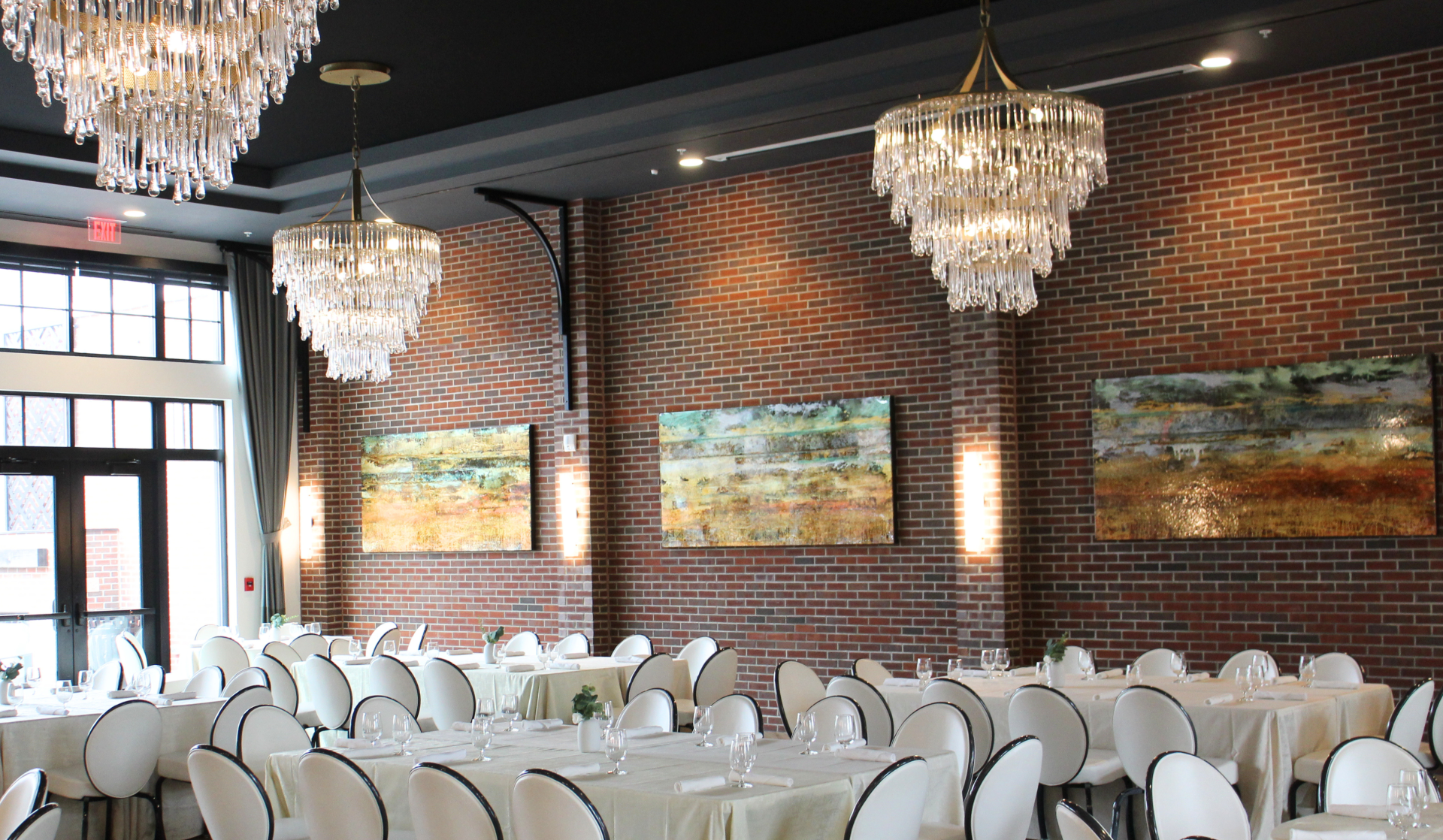 a room with tables and chairs and chandeliers