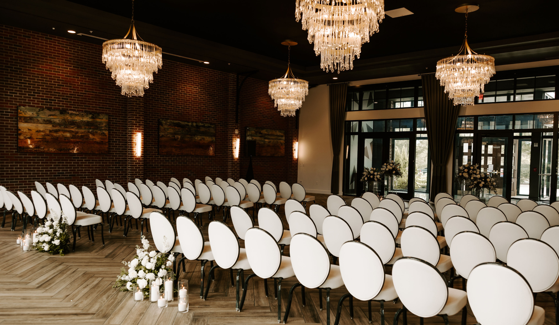a room with white chairs and chandeliers