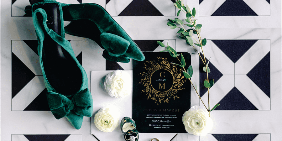 a wedding invitation with flowers and shoes