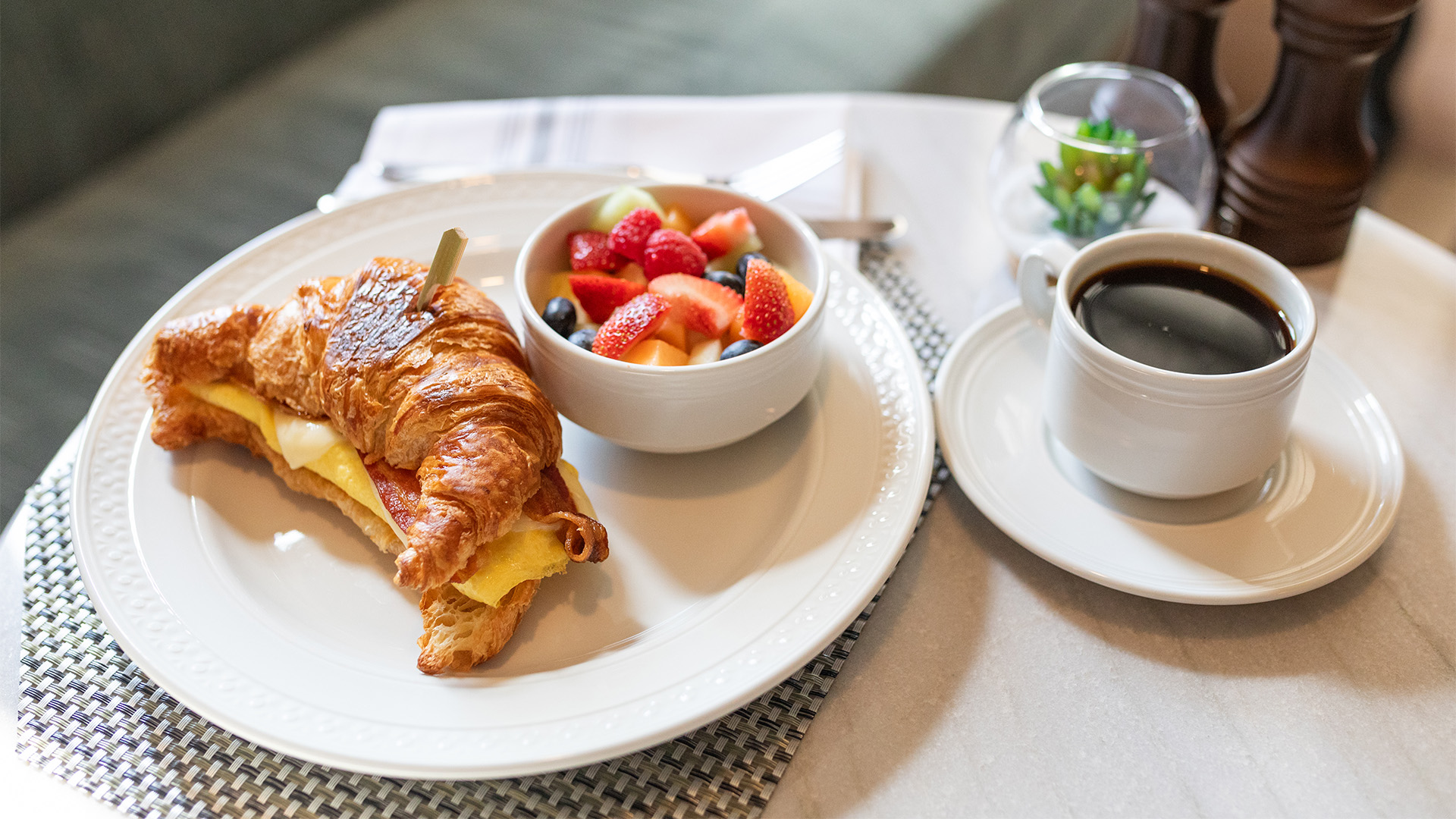 a croissant and fruit on a plate