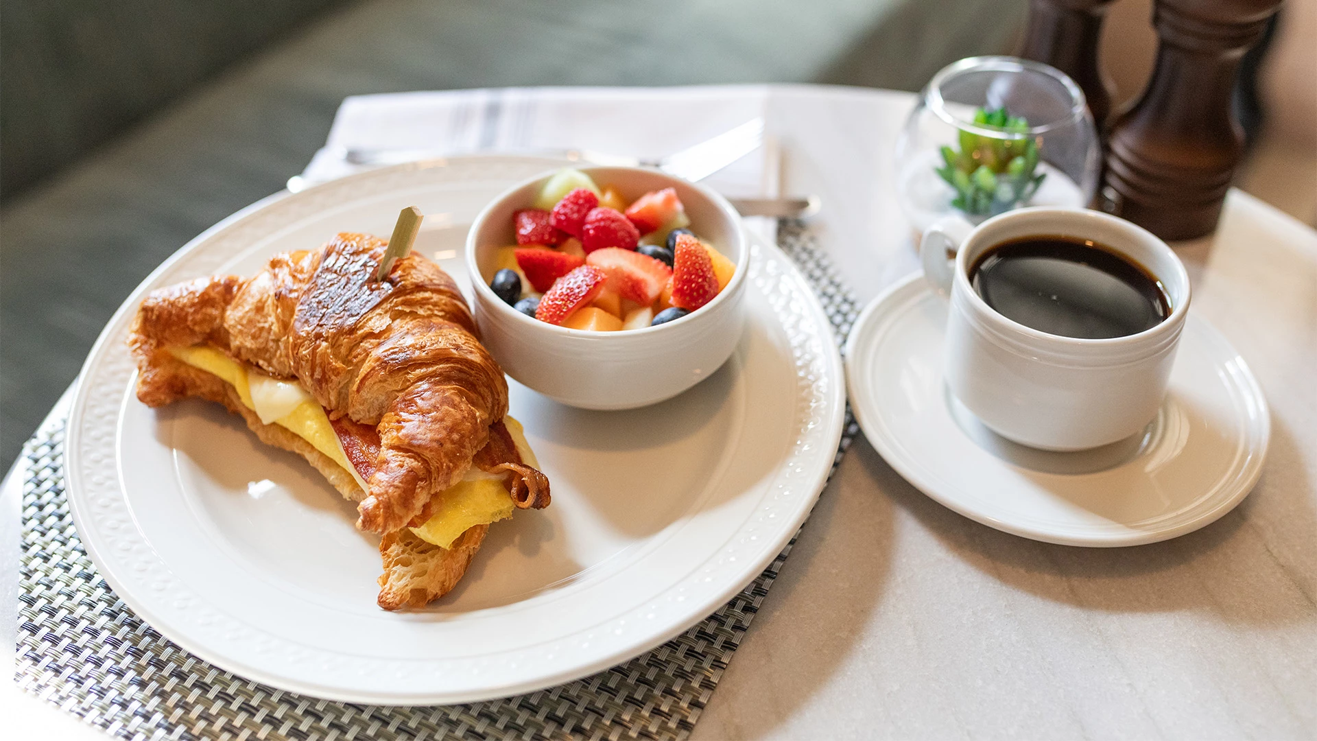 a croissant and fruit on a plate