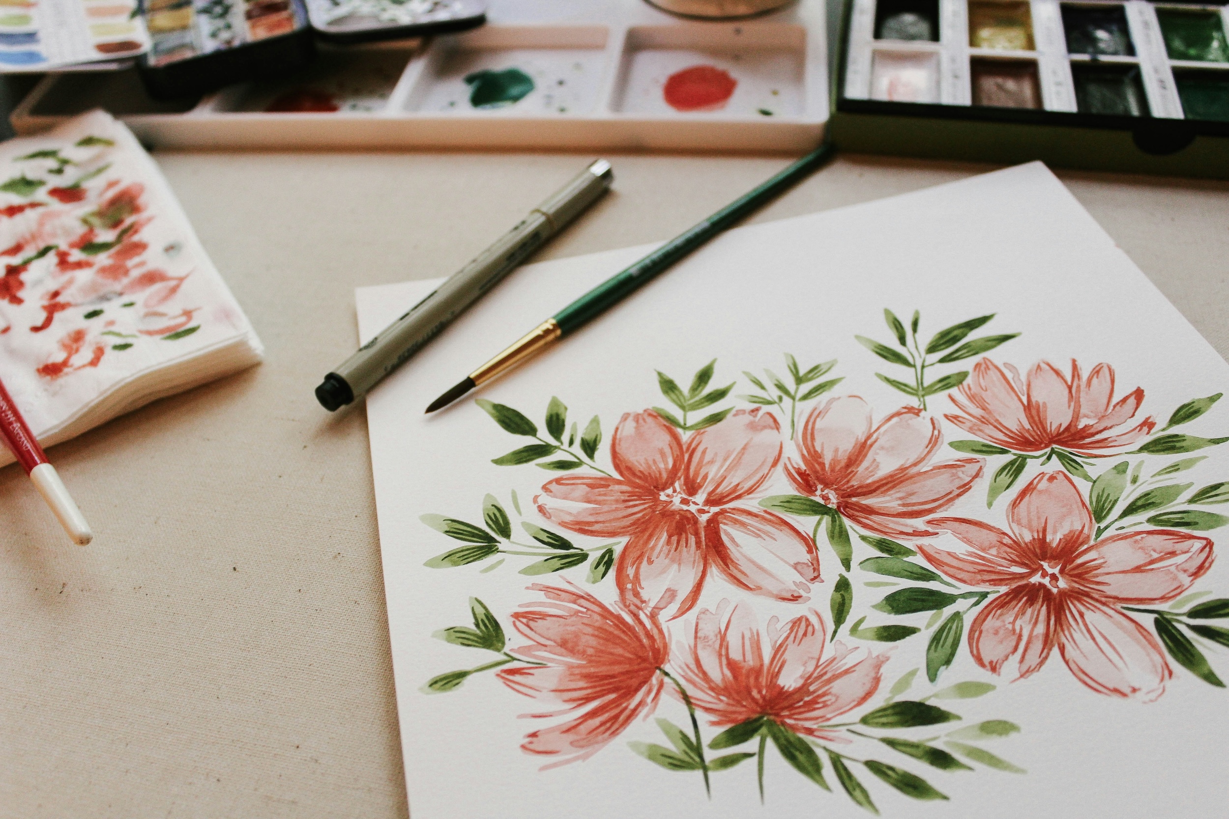 a painting of flowers and a brush on a table