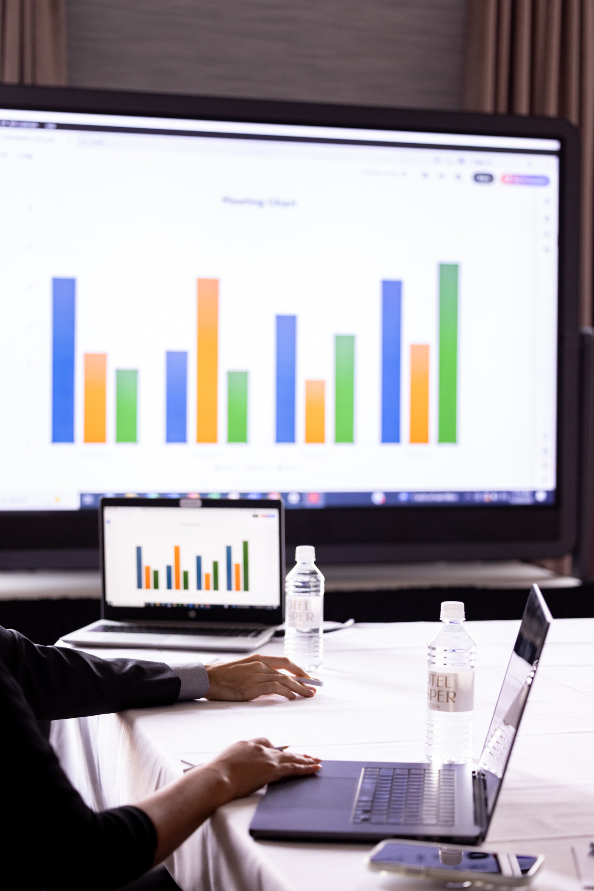 a person sitting at a table with a laptop and water bottle