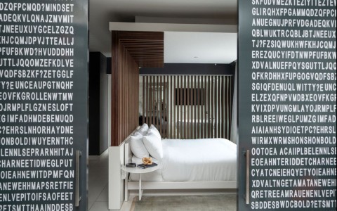 a bed with a table and a coffee table in a room with white letters