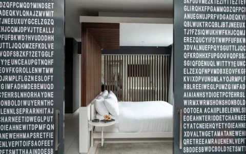 a bed with a table and a coffee table in a room with white letters