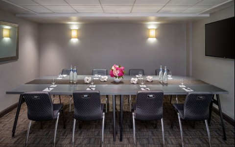 a table with chairs and a vase of flowers