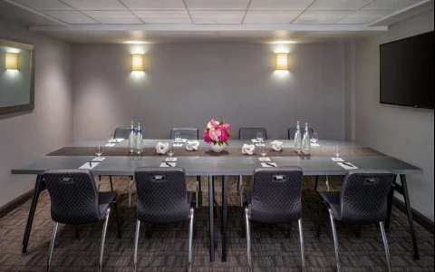 a table with chairs and a vase of flowers