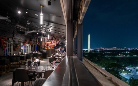 a restaurant with a tall monument in the background
