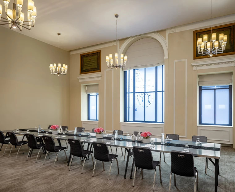 a long conference room with chairs and chandeliers