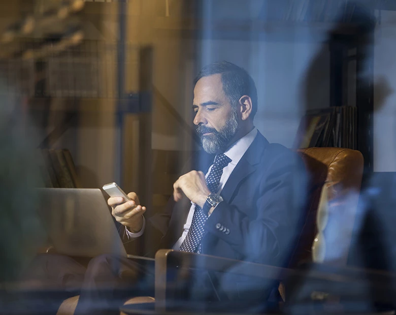a man in a suit looking at his phone