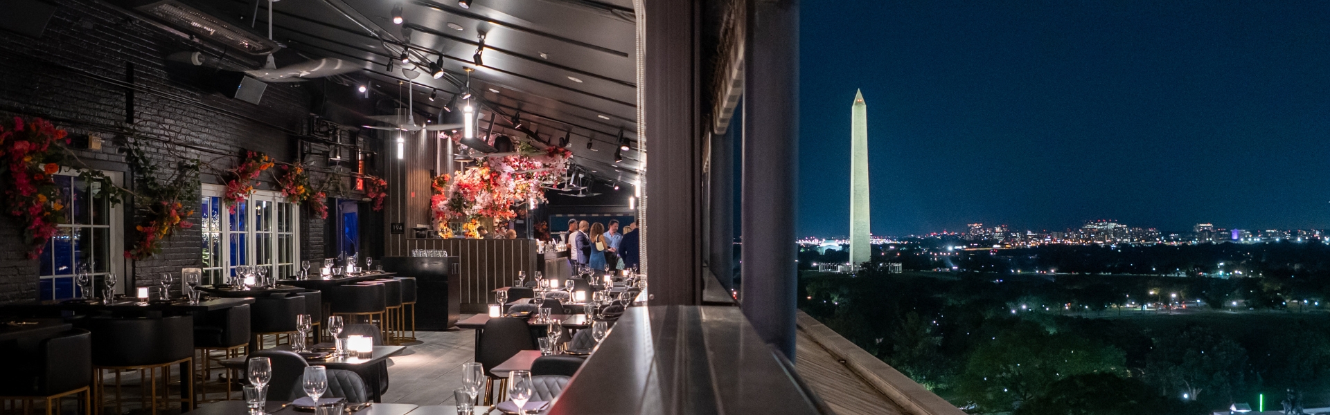 split view of empty restaurant interior and view of washinton monument and dc skyline at night
