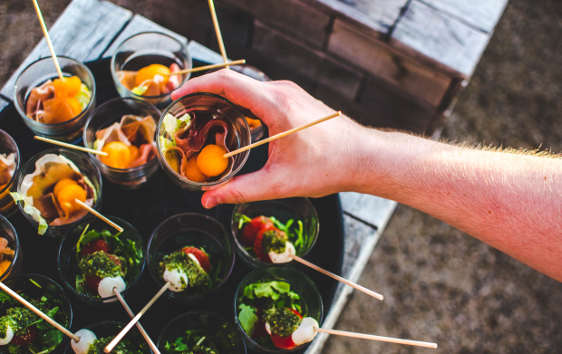 a hand holding a stick with food in it