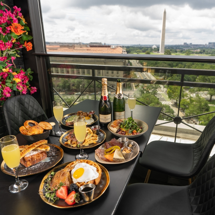 a table with six plates of an assortment of breakfast food and filled champagne glasses 