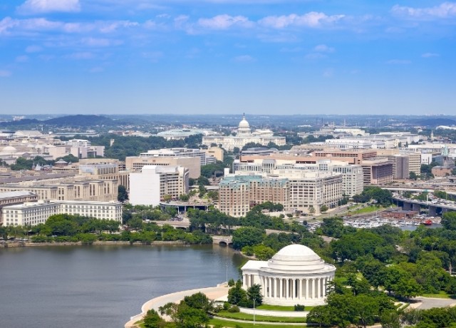 a white building with a domed roof and a body of water