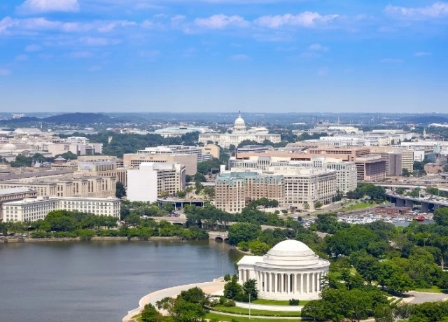 a white building with a domed roof and a body of water preview