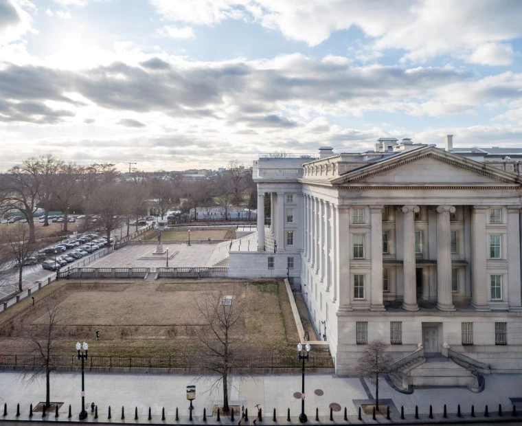 a large white building with columns and a lawn in front of it