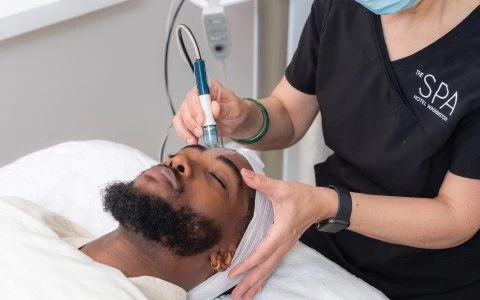 a person using a device to get a facial treatment