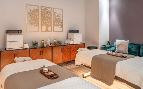 a room with two beds and a blue chair