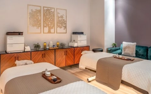 a room with two beds and a blue chair