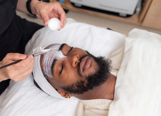 a man lying down with a white object on his face preview