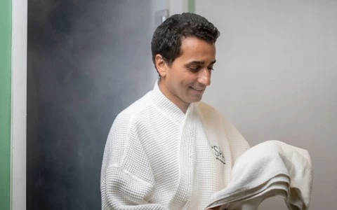a man in a white robe holding a towel