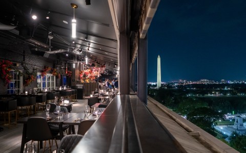 a restaurant with a tall monument in the background