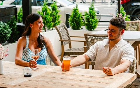 a man and woman sitting at a table with drinks