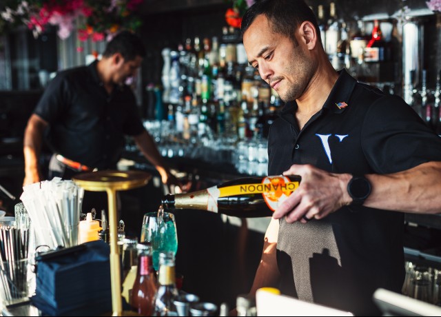 a man pouring a drink into a bottle preview