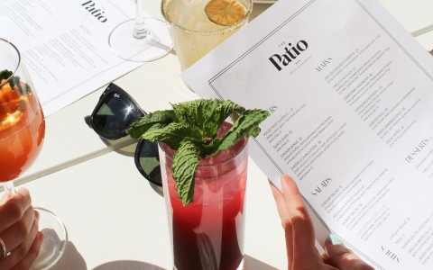 a person holding a menu and a drink