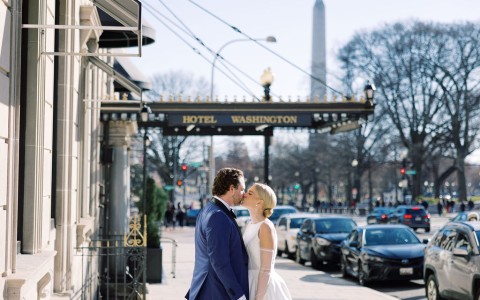 a man and woman kissing on a sidewalk