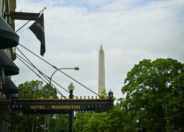 a sign with a flag and a monument in the background preview