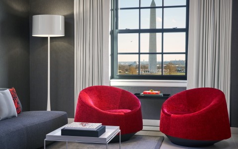 a room with red chairs and a large window
