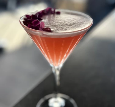 a glass with a drink and flowers on it