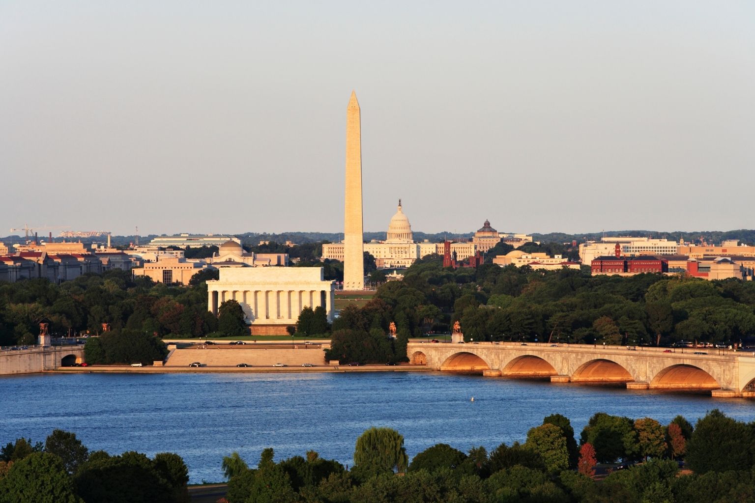 a body of water with a bridge and a monument in the background