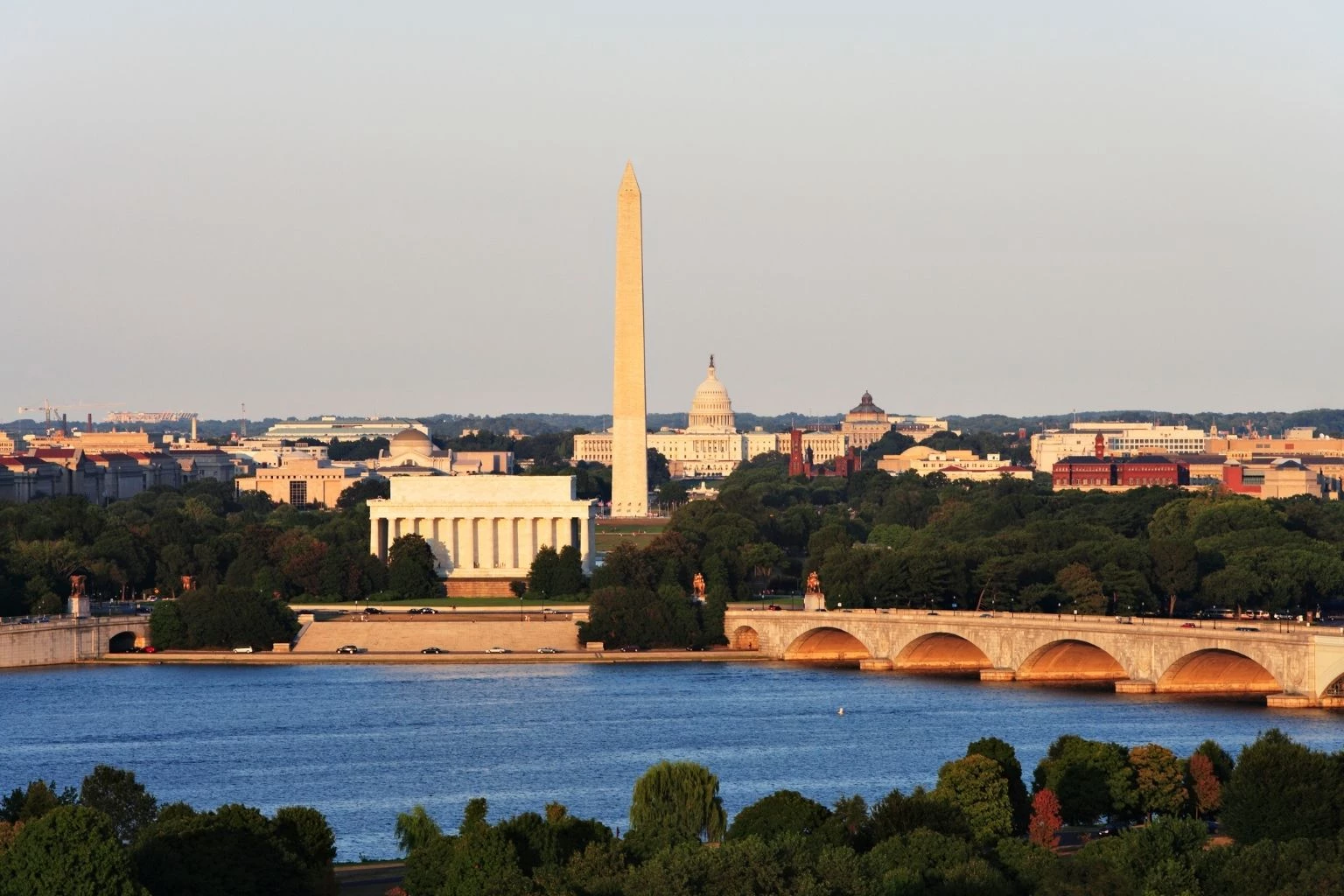 a body of water with a bridge and a monument in the background