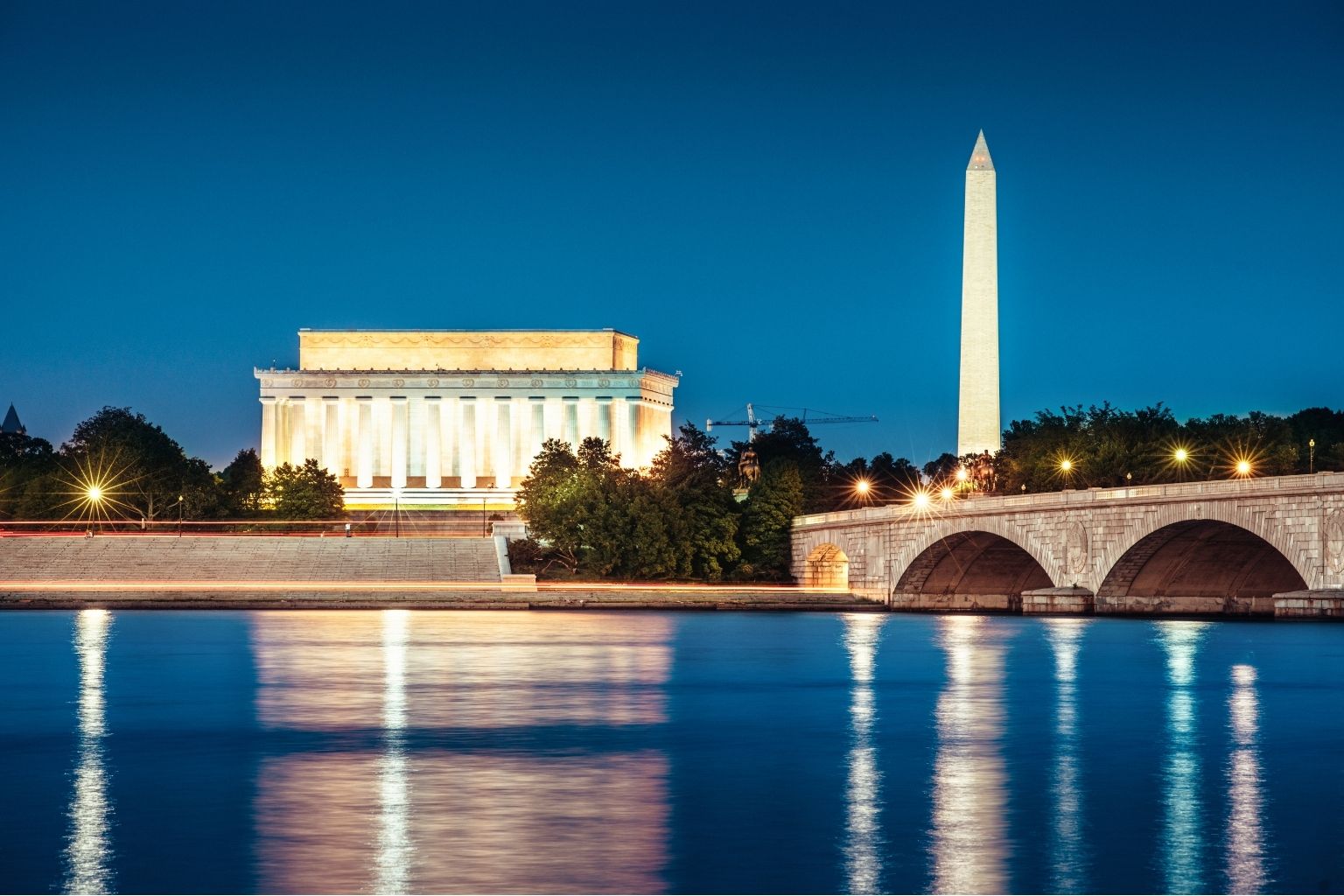 a bridge over a body of water with a monument and a stone building