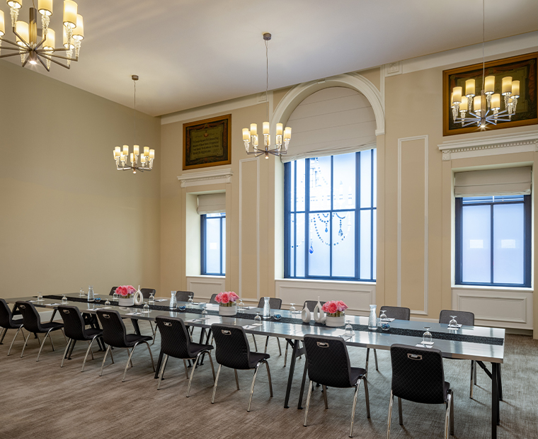 a long conference room with chairs and chandeliers