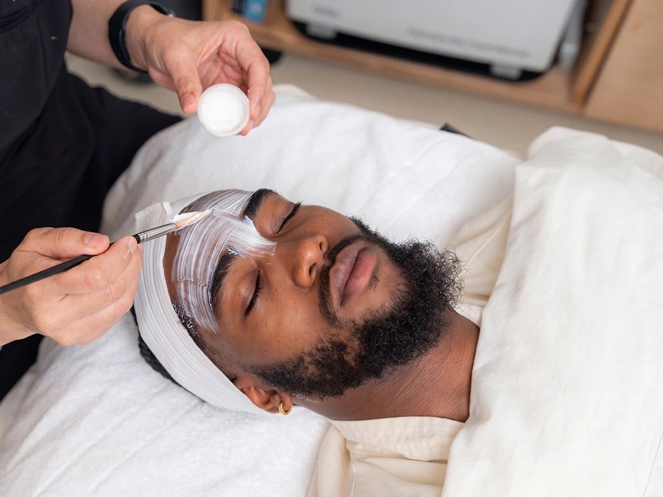 a man lying down with a white object on his face