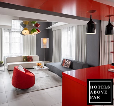 a room with a red chair and two couches and the hotels above par logo
