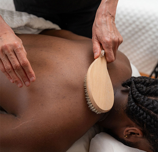 a person using a massage brush to massage a woman's back