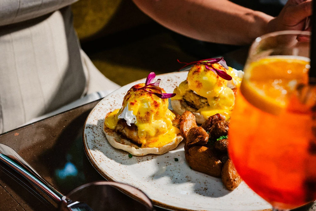 a plate of food with a glass of orange juice
