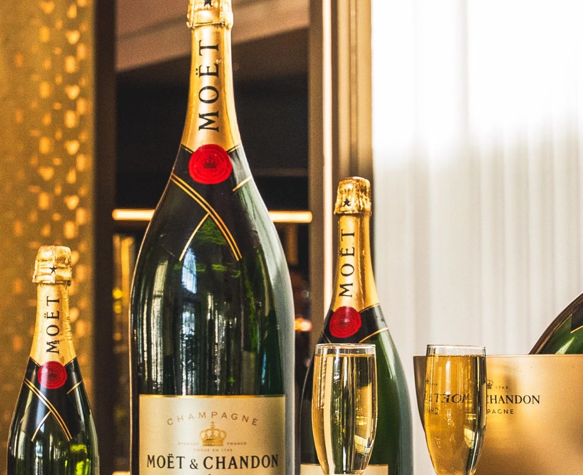 a bottle of champagne next to a glass of champagne