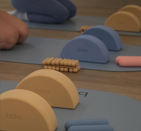 various types of bala workout equipment placed on blue bala branded yoga mats