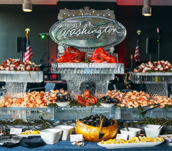 an ice sculpture with the hotel logo and surrounded by various types of seafood